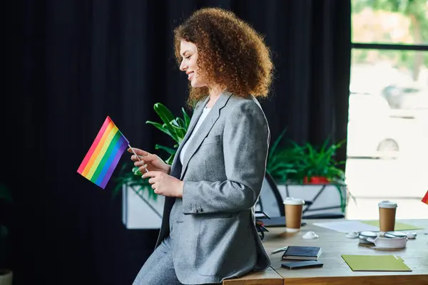 A coworker joyfully holds a rainbow flag, embodying the spirit of inclusivity and pride. — Stock Photo