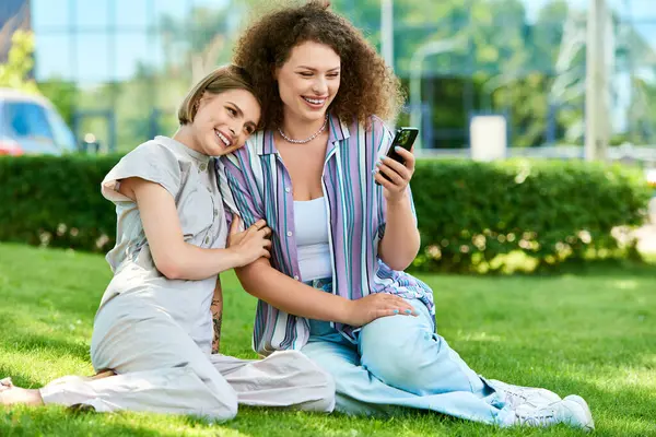 Two friends relax on the grass, engaging in joyful conversation and sharing their favorite moments. — Stock Photo