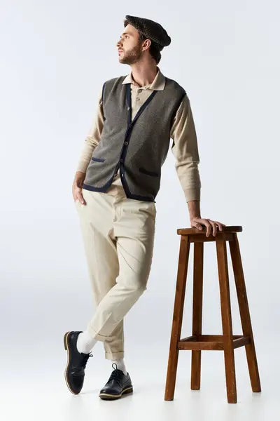 A stylish man leans casually on a stool, radiating charm and sophistication. — Stock Photo