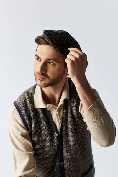A dapper individual showcases his flair for fashion while making a subtle adjustment to his hat. — Stock Photo