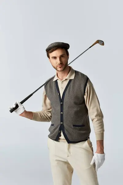 A stylish man displays confidence while holding a golf club, showcasing his elegant outfit. — Stock Photo