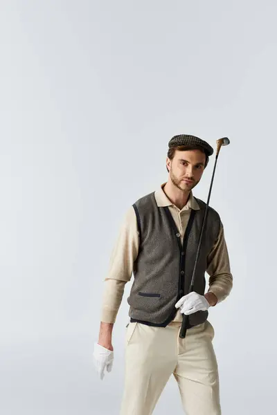 A well dressed individual stands elegantly, holding a golf club, exuding charm and confidence. — Stock Photo