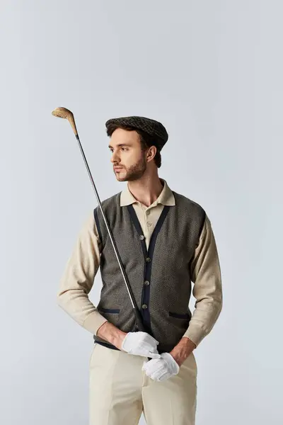 Vestito in abiti da golf vintage, posa con fiducia con un golf club in mano. — Foto stock