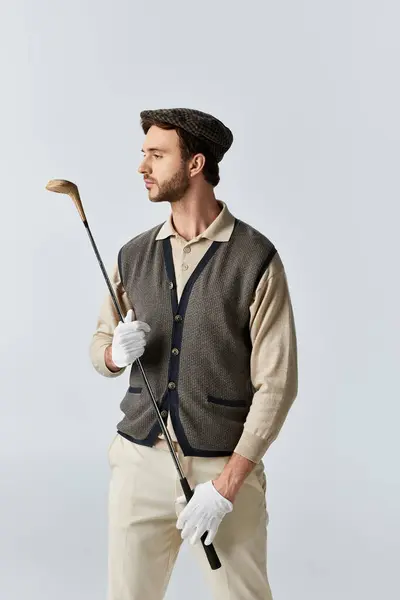 The well dressed individual stands gracefully holding a golf club, showcasing his elegant style. — Stock Photo