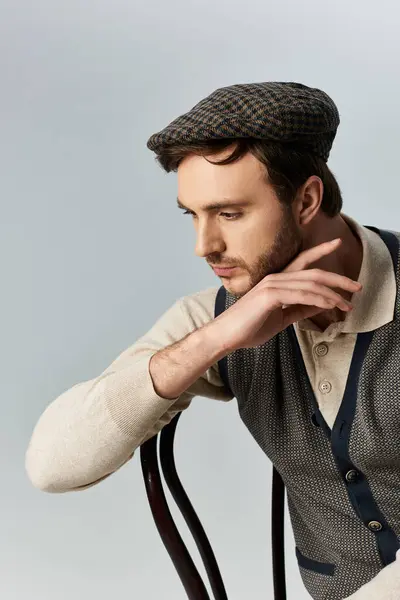 Un gentleman dapper penché sur une chaise, mettant en valeur sa tenue élégante et son charme. — Photo de stock