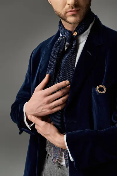 A stylish man tweaks his scarf, radiating charm in a tailored jacket and refined accessories. — Stock Photo