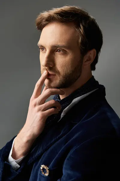 A handsome man, dressed elegantly, reflects deeply while posing with a finger on his lips. — Stock Photo