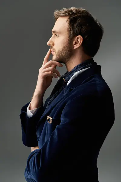 A handsome man dressed in a sharp blue suit stands confidently, lost in thought. — Stock Photo