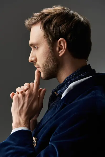 A handsome gentleman contemplates with a finger against his lips, exuding elegance and charm. — Stock Photo