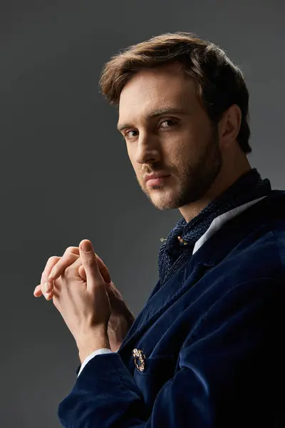 Un hombre elegante con una expresión de confianza muestra su moda dandy en un ambiente dramático. - foto de stock