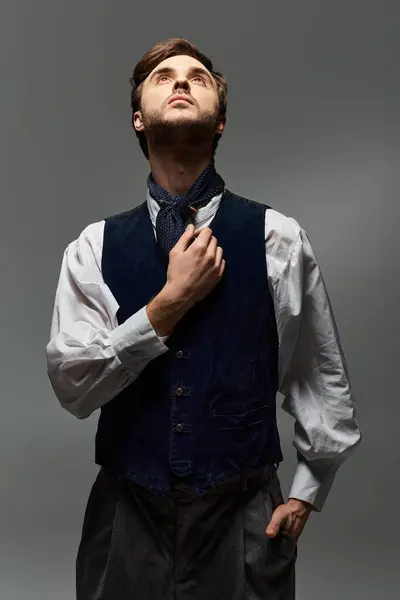 Elegantly dressed, a handsome dandy contemplates while looking skyward in a dramatic light. — Stock Photo