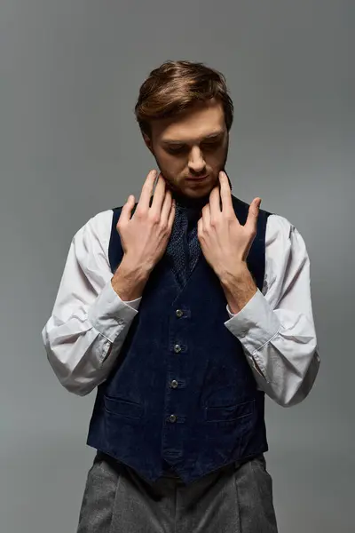 A handsome individual in a stylish outfit thoughtfully adjusts his look with confidence. — Stock Photo