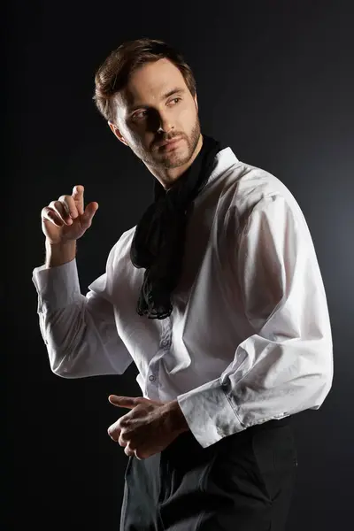 The handsome figure elegantly adjusts his attire, exuding charm and confidence in low light. — Stock Photo