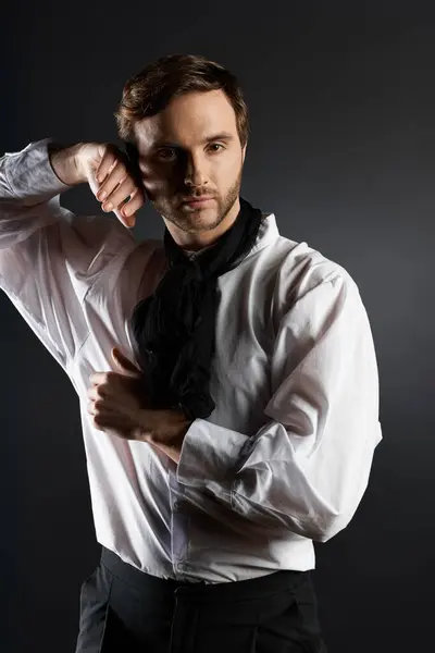 Un hombre guapo y elegante muestra su traje dandi contra un telón de fondo oscuro, encarnando la elegancia. — Stock Photo