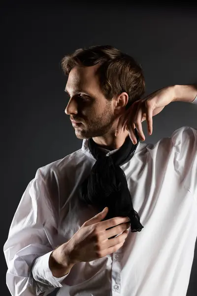 The dandy showcases his elegance, adorning a striking white shirt and black scarf. — Stock Photo