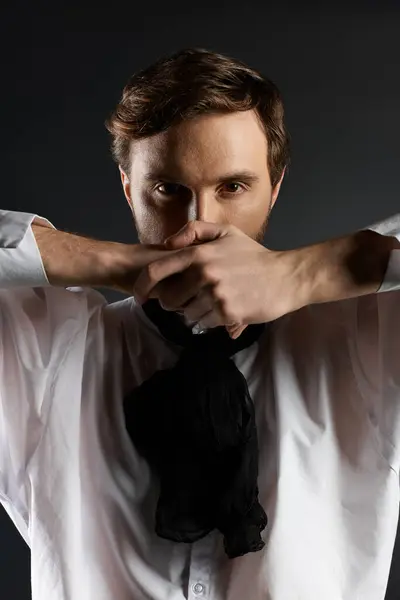 A dapper gentleman strikes a bold pose, obscuring his face with hands while exuding charm. — Stock Photo