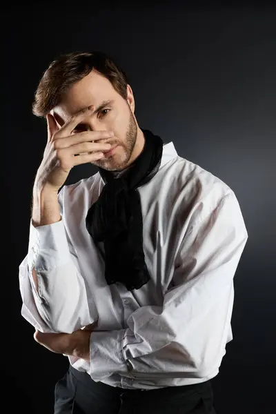 A handsome man in a white shirt ponders thoughtfully, displaying a dandy flair and elegance. — Stock Photo