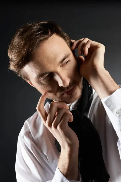 Um homem bonito vestido de traje nítido ajusta suavemente seu lenço, pensando profundamente. — Fotografia de Stock