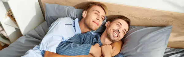 A joyful couple nestled together in bed, sharing smiles and affection during a peaceful morning. — Stock Photo
