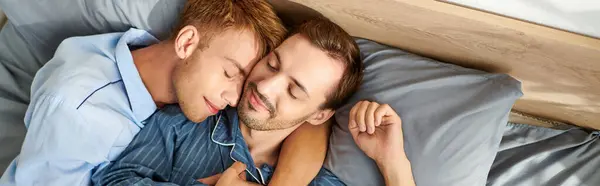 Una coppia gay in pigiama condivide un momento tenero insieme, abbracciando gioiosamente il calore della mattina. — Foto stock