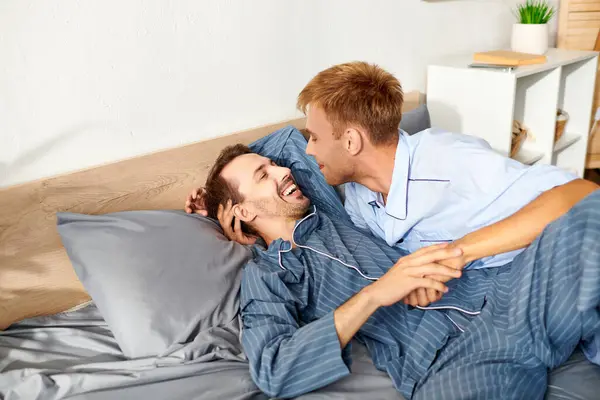 Ein fröhliches homosexuelles Paar teilt herzliche Momente im Pyjama und sonnt sich an einem friedlichen Morgen in der Liebe zueinander. — Stockfoto