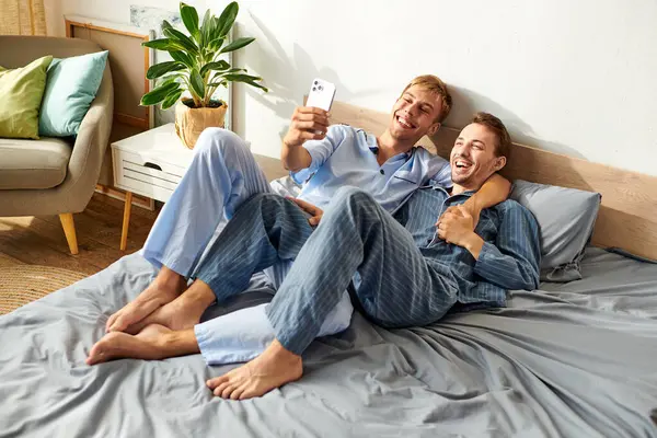 This joyful couple enjoys a cozy morning together, smiling and sharing a light moment in their pajamas. — Stock Photo