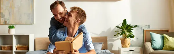 In a warm and inviting bedroom, a loving gay couple shares laughter and affection while relaxing in pajamas. — Stock Photo