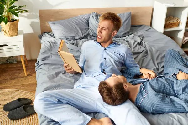 Two partners share a quiet morning, wrapped in pajamas, reading and enjoying each others company. — Stock Photo
