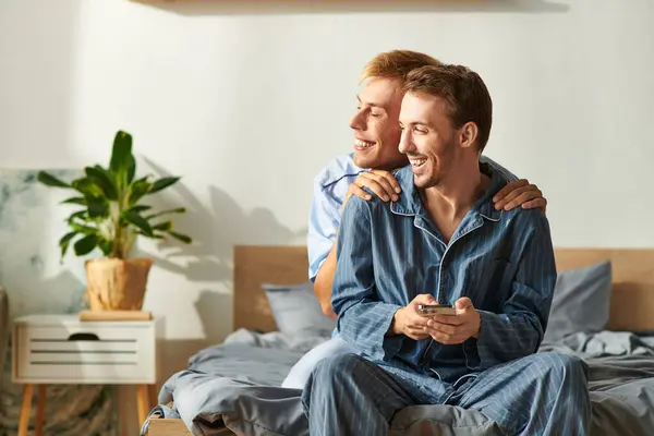 A loving gay couple enjoys a cozy morning in pajamas, sharing laughter while spending quality time together. — Stock Photo