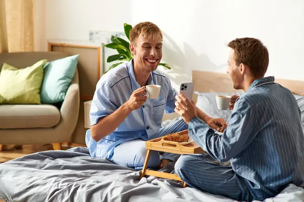 Una coppia felice si gode la colazione in pigiama, abbracciando amore e connessione alla luce del mattino. — Foto stock