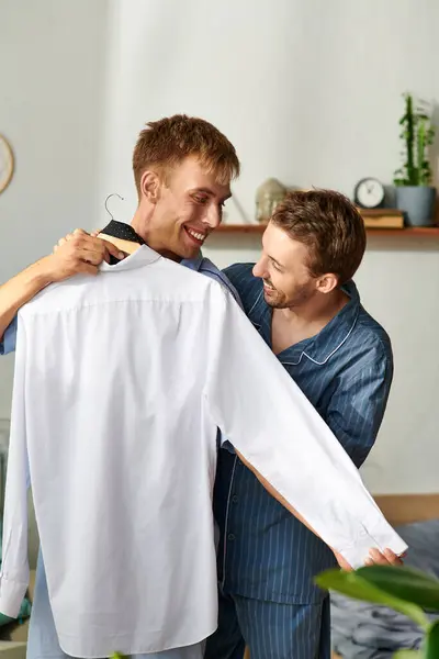 Zwei fröhliche Partner verbringen einen unbeschwerten Moment im Schlafanzug, während sie sich auf den bevorstehenden Tag vorbereiten. — Stockfoto