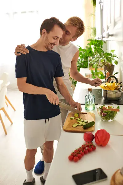 A loving couple shares a delightful moment in their modern kitchen, preparing a fresh salad together. — Stock Photo