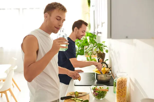 A joyful couple prepares salad together in a stylish kitchen, enjoying each others company and love. — Stock Photo