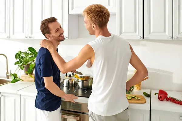 Un couple amoureux partage le rire tout en faisant une salade vibrante dans leur cuisine. — Photo de stock