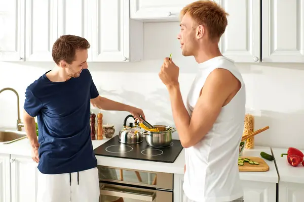 A couple happily cooks together, and enjoying each others company in a vibrant kitchen. — Stock Photo