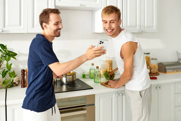 Two men happily prepare a meal in their stylish kitchen, enjoying togetherness and love. — Stock Photo