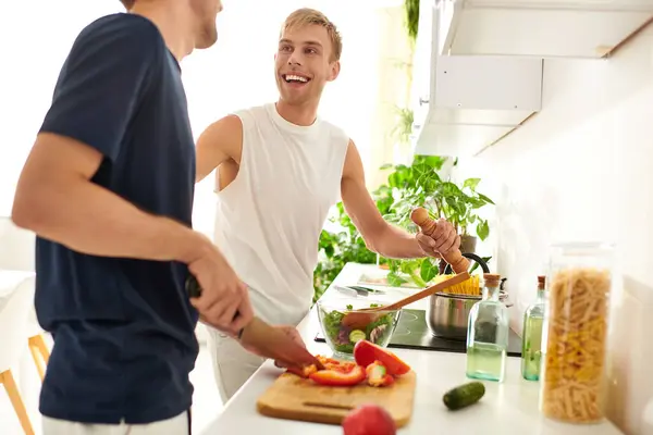 A loving couple chops vegetables side by side, sharing smiles and laughter in their cozy kitchen. — Stock Photo