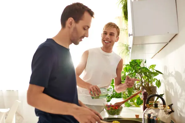 In a bright kitchen, a gay couple happily prepares a lunch and enjoying their time together. — Stock Photo