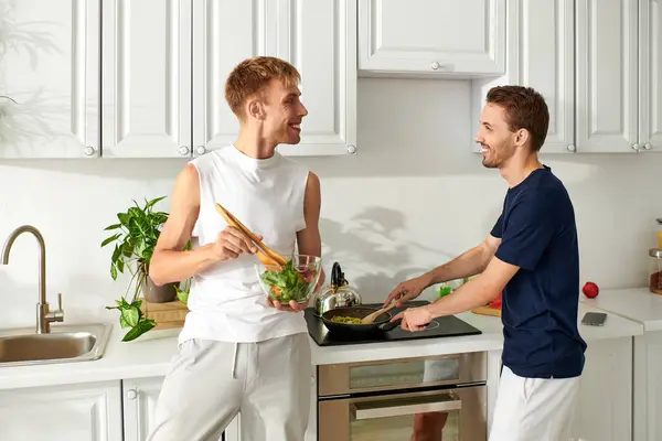 A loving couple happily cooks in their contemporary kitchen, sharing joy while making a fresh meal. — Stock Photo