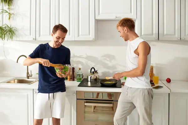 Two men joyfully prepare a fresh lunch in their stylish kitchen filled with love. — Stock Photo