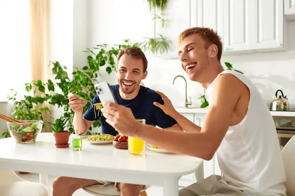 Una coppia felice ridendo e prendendo selfie nella loro cucina elegante. — Foto stock