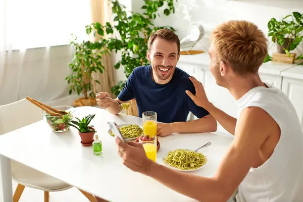 In una luminosa cucina moderna, una coppia gioiosa che mangia, abbracciando il loro amore. — Foto stock