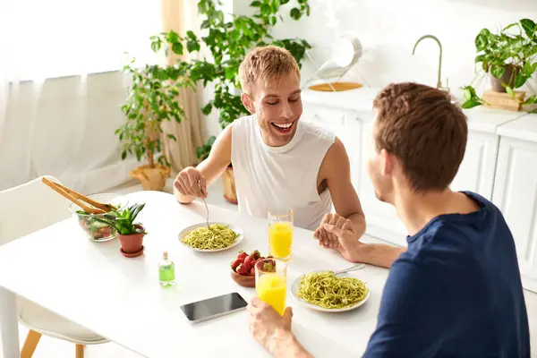 Una coppia amorevole pranza nella loro cucina contemporanea, condividendo sorrisi e risate. — Foto stock