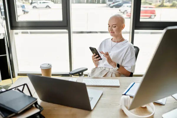 A young bald woman dressed elegantly engages with her smartphone in a stylish office. — Stock Photo