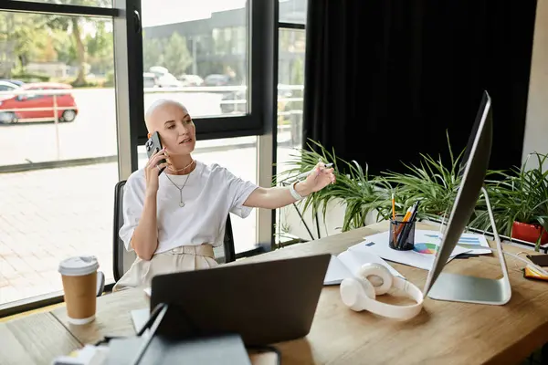 A young bald woman elegantly dressed talks on the phone, surrounded by greenery and natural light. — Stock Photo