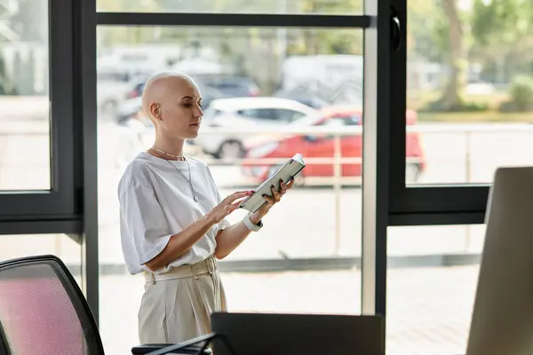 Die stylische Frau interagiert selbstbewusst mit ihrem Gerät in einem hellen Arbeitsbereich. — Stockfoto