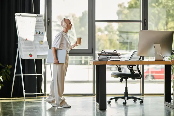 A young, bald woman in elegant attire holds a coffee cup in a chic office. — Stock Photo