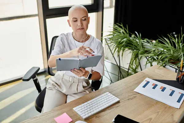 In a chic office space, a young bald woman in stylish attire examines her notes intently. — Stock Photo