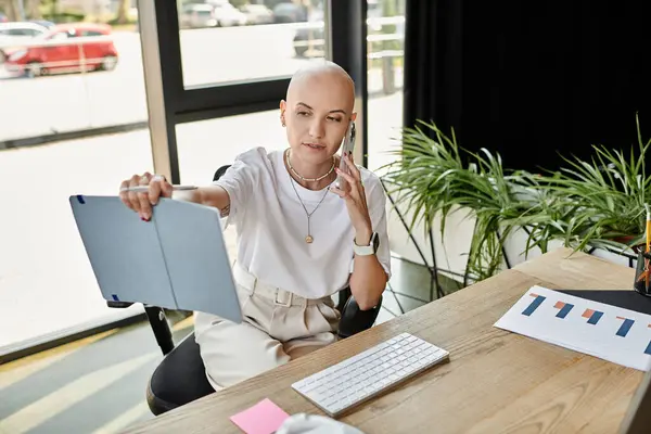 A young bald woman dressed elegantly speaks on the phone while reviewing documents. — Foto stock