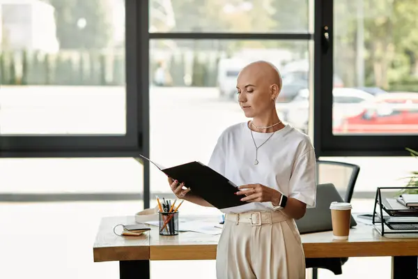 A young bald woman stands poised, examining documents in a bright and elegant office environment. — Stock Photo